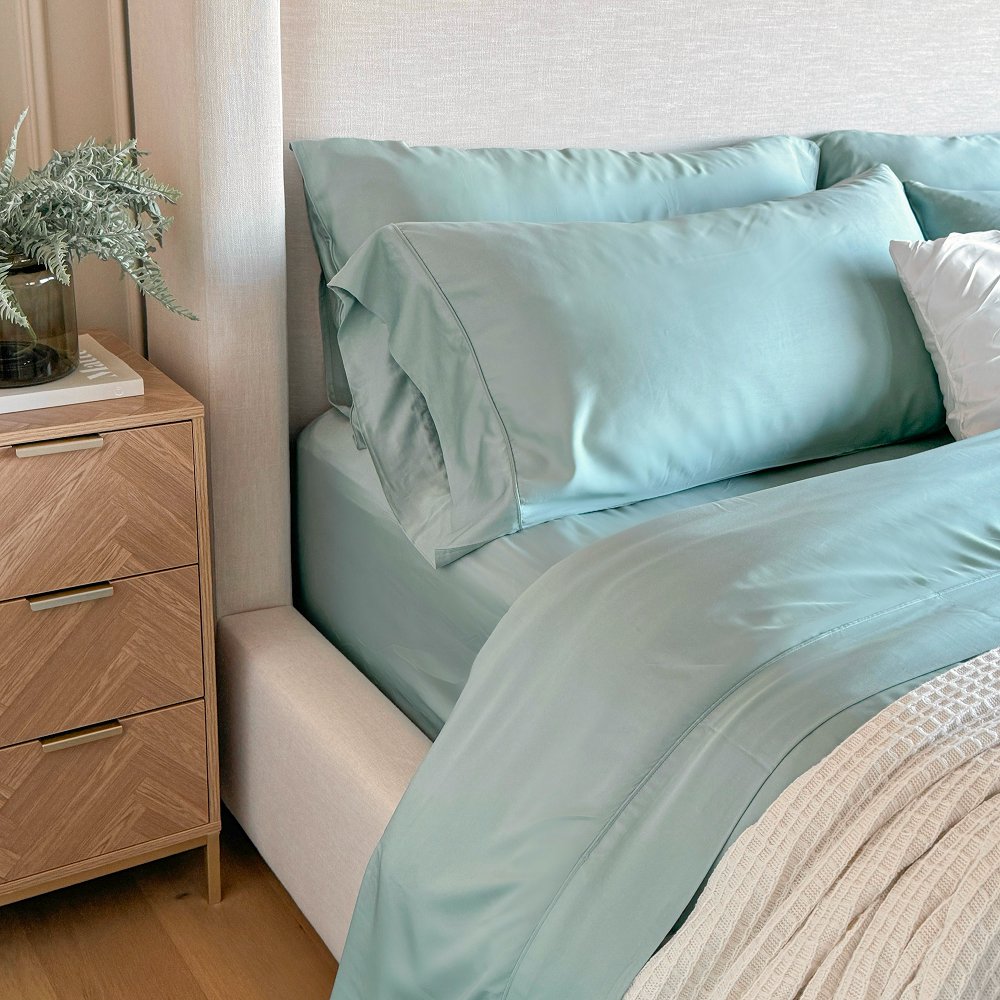 Comment avoir moins chaud la nuit : conseils et produits efficaces - Linge de lit blanc léger avec un tissu respirant et des couches minimales pour aider à prévenir la surchauffe pendant le sommeil.